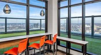 a dining area with orange chairs and a view of the city at Expo, Minneapolis Minnesota