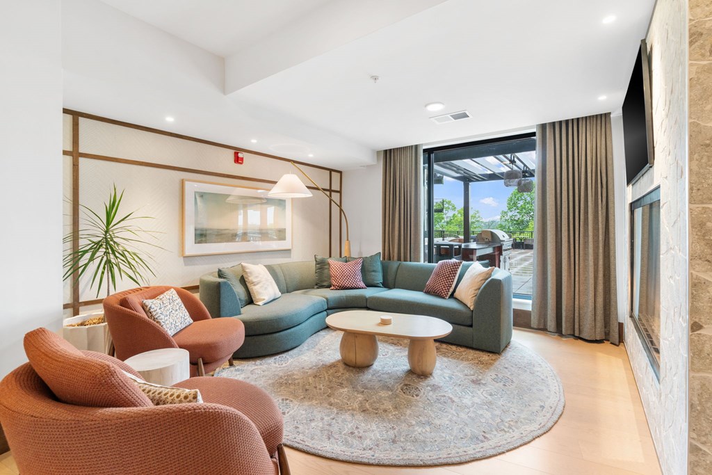 Comfortable seating across from the fireplace in the Clubroom, a reservable community room at Lilia in Lilydale, MN 55118