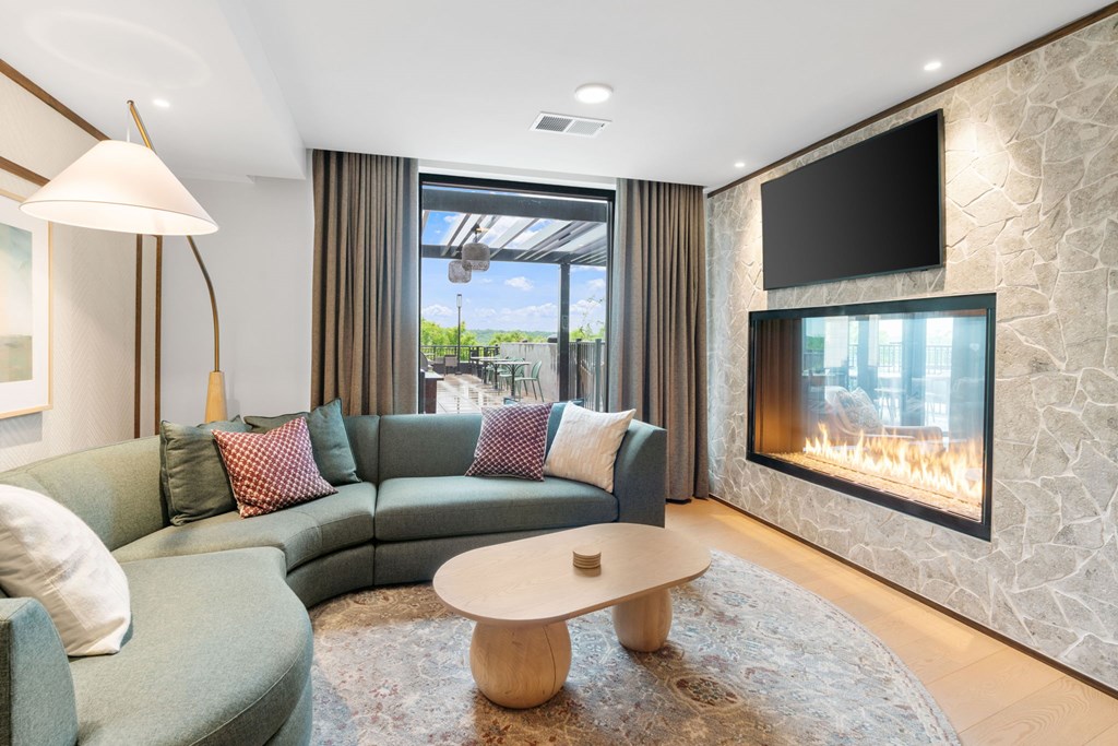 Comfortable seating across from the fireplace in the Clubroom, a reservable community room at Lilia in Lilydale, MN 55118