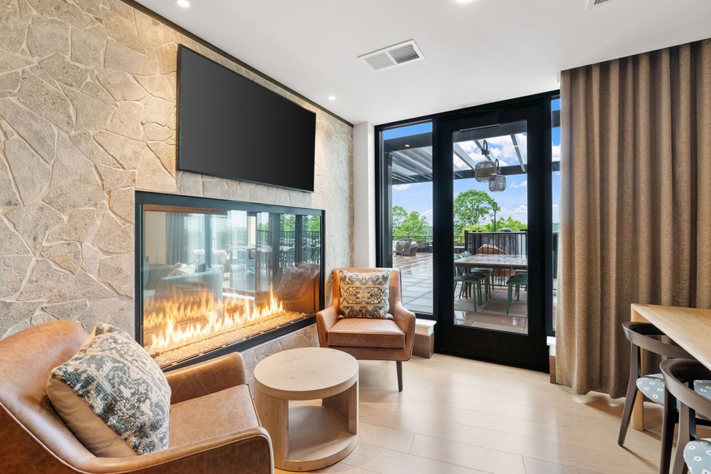 Comfortable seating across from the fireplace in the Clubroom, a reservable community room at Lilia in Lilydale, MN 55118