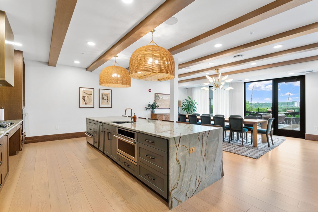 The long dining table and oversized kitchen in the Private Dining Room, a reservable community room at Lilia in Lilydale, MN 55118