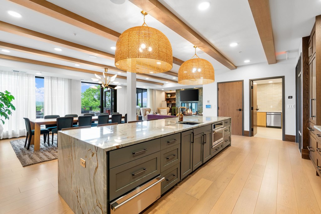 The long dining table and oversized kitchen in the Private Dining Room, a reservable community room at Lilia in Lilydale, MN 55118