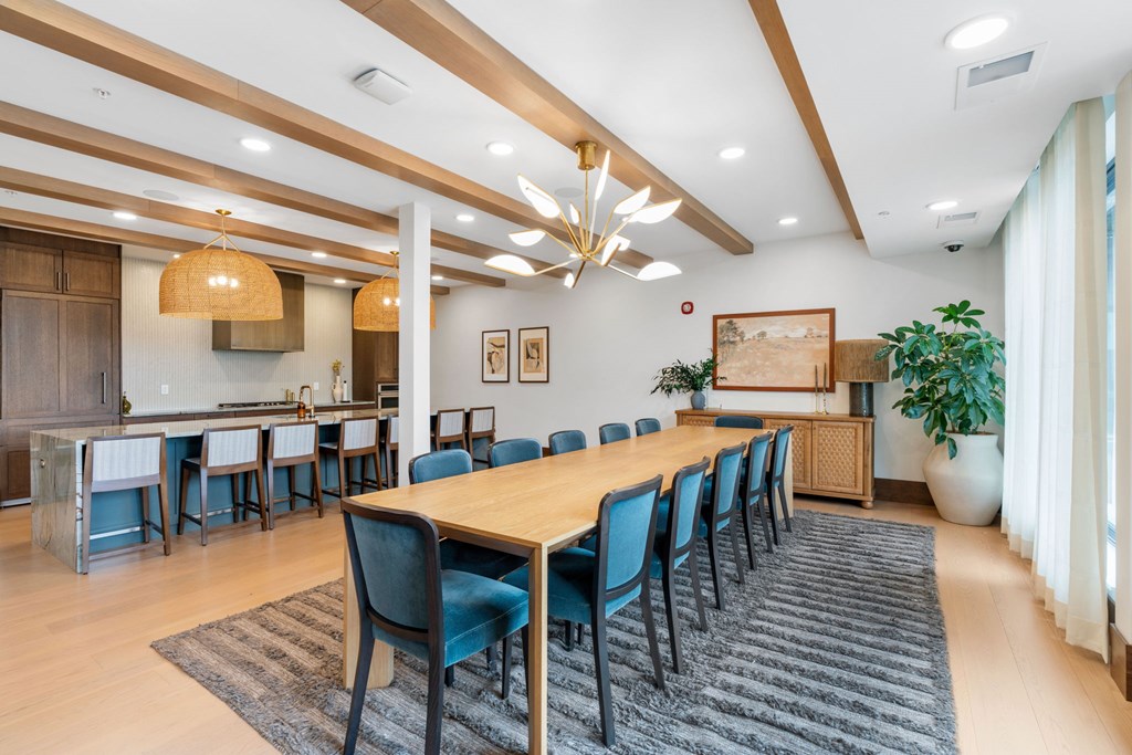 The long dining table and oversized kitchen in the Private Dining Room, a reservable community room at Lilia in Lilydale, MN 55118
