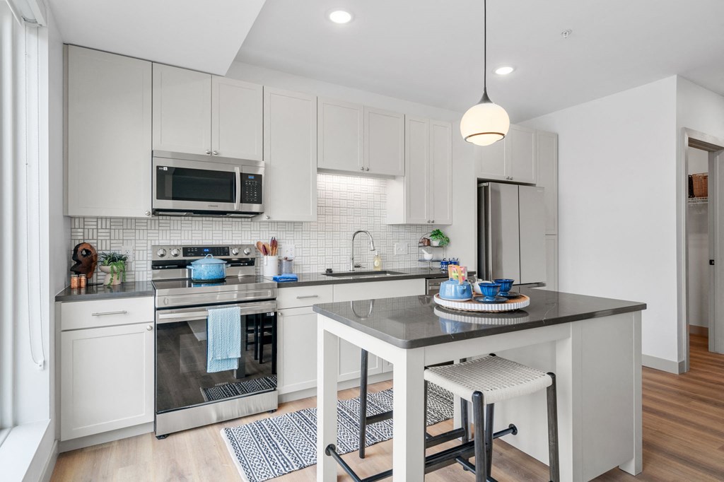 a kitchen with white cabinets and a counter top at The Mera, St Louis Park, MN