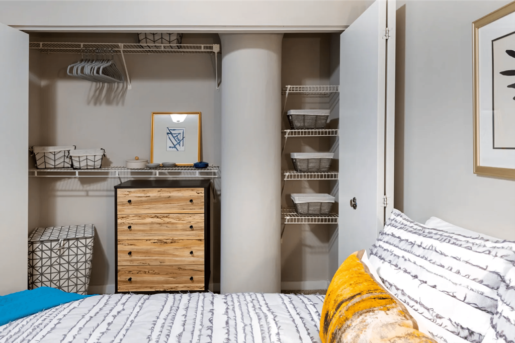 a closet in a bedroom with a bed and a dresser  at The Cosmopolitan, St Paul, Minnesota