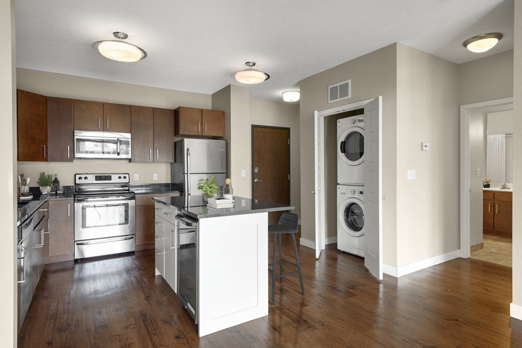 a kitchen with an island and a washer and dryer at Be @ Axon Green, Minneapolis, MN