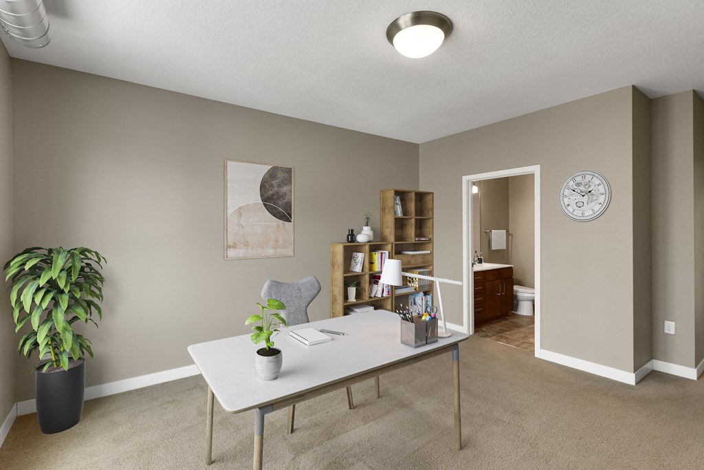 a home office with a large potted plant on the side of the desk at Be @ Axon Green, Minneapolis, Minnesota