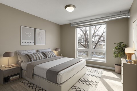 a bedroom with a large window and a bed