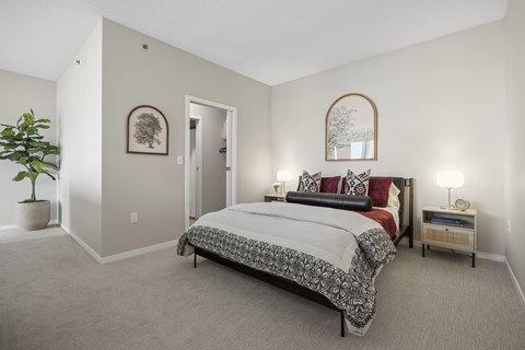 Lofted bedroom at The Ellory - A bedroom with a large bed, a potted plant, and a mirror on the wall.