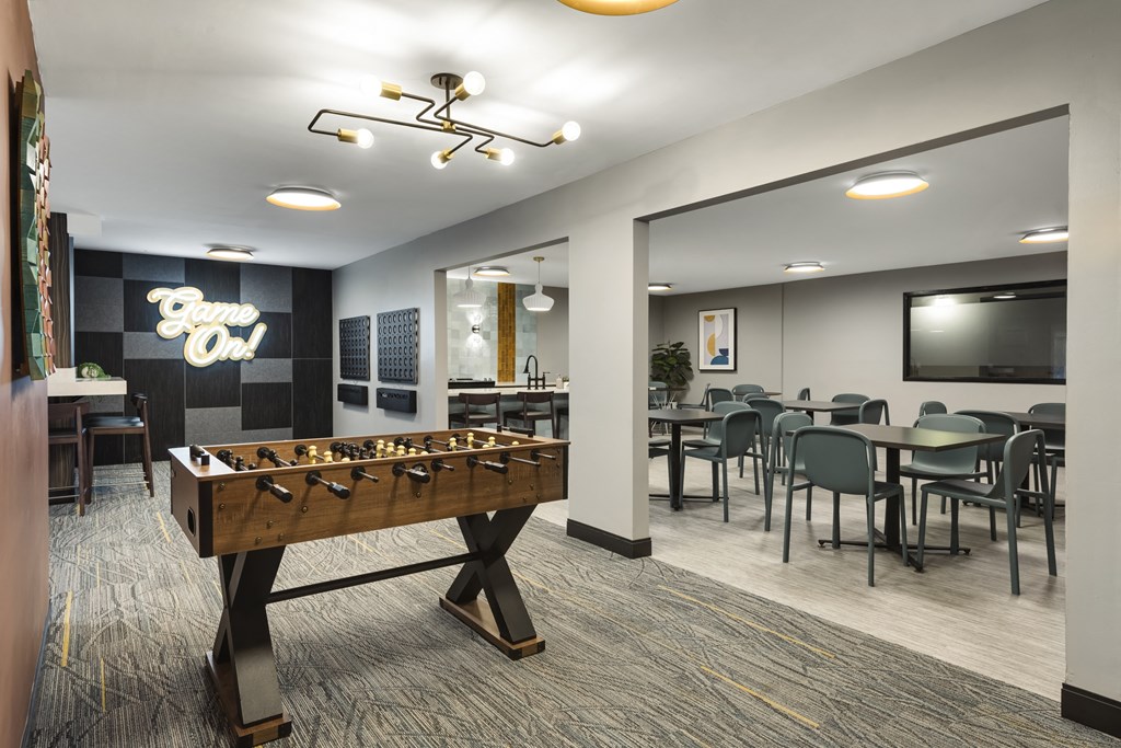 a game room with a foosball table and a tv  at Cedars Lakeside, Little Canada, Minnesota