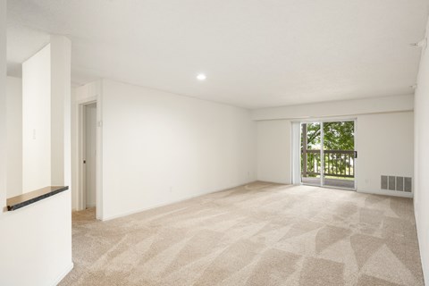 the living room and dining room of a house with white walls and a large window
