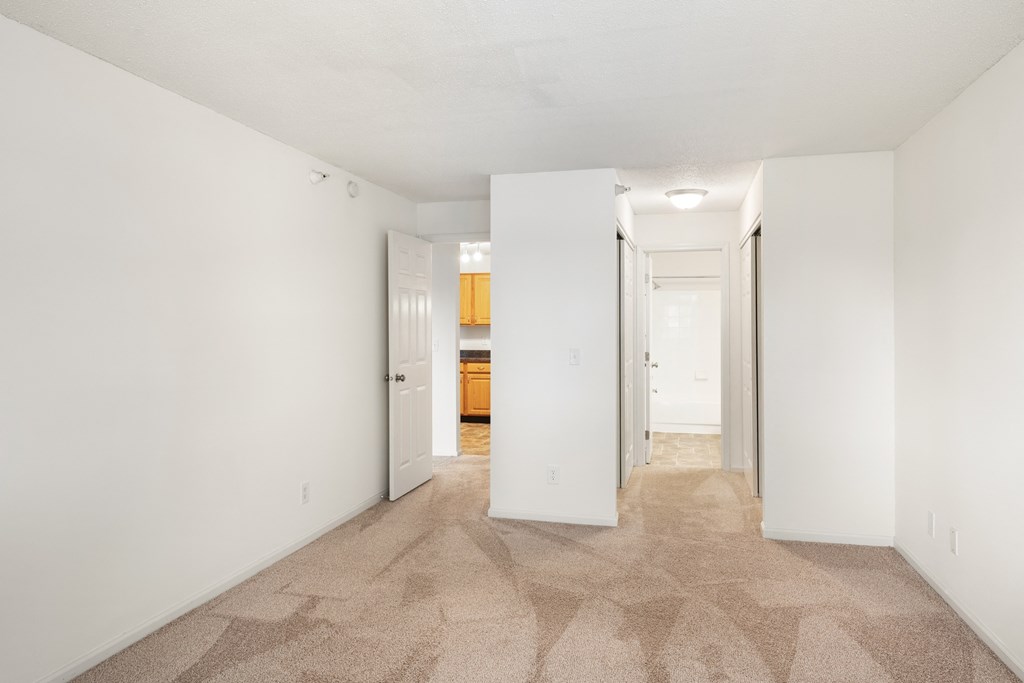 a spacious living room with white walls and a carpeted floor at Cityscape, St Louis Park, 55416