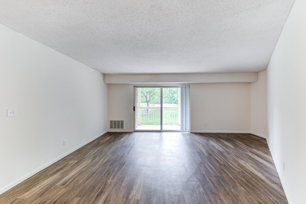 the spacious living room with wood flooring and a sliding glass door at Cityscape, St Louis Park, MN, 55416