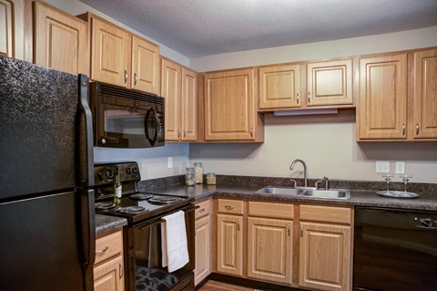 a kitchen with black appliances and wooden cabinets