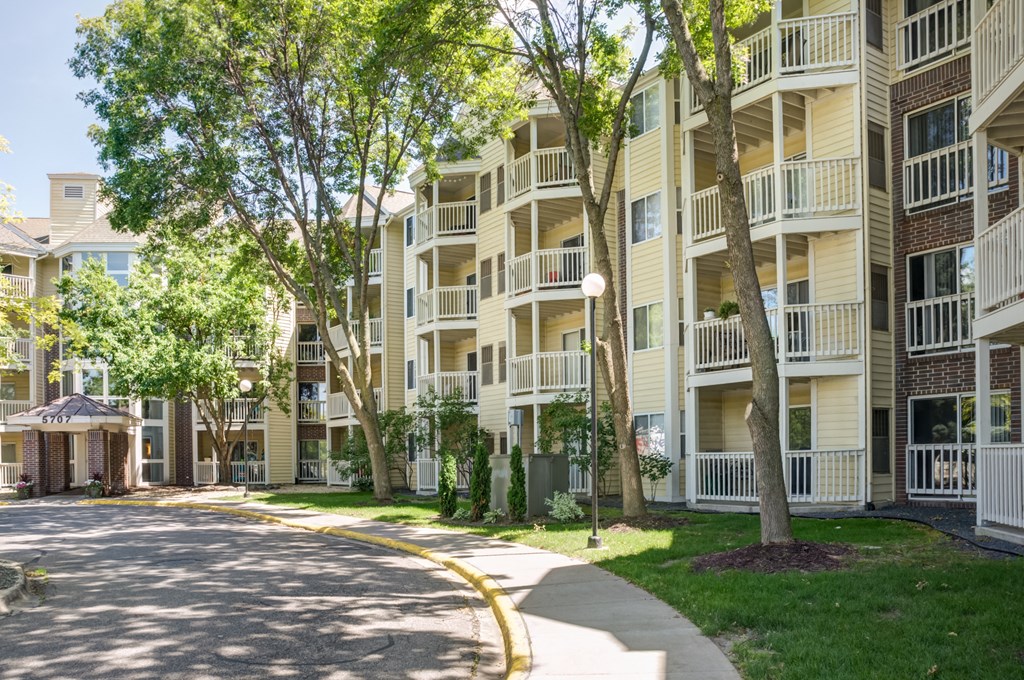 a street view of an apartment building with trees and a sidewalk at Cityscape, Minnesota, 55416