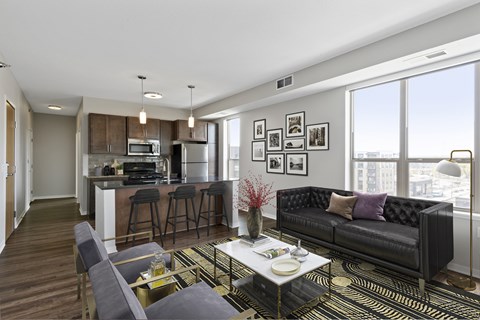 A modern living room with a black couch and a coffee table.
