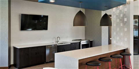 a kitchen in a hotel with a counter and stools