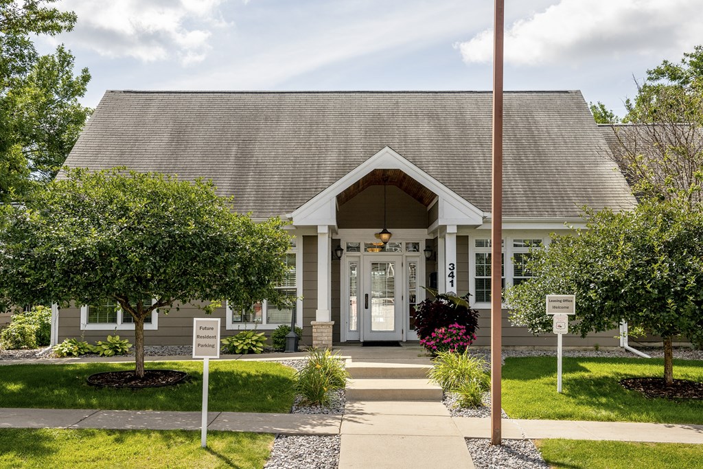the front entrance of a church with a porch and a sidewalk in front of it