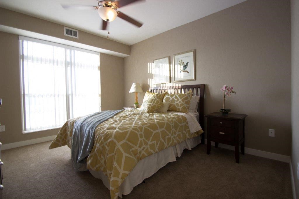a bedroom with a bed and a ceiling fan