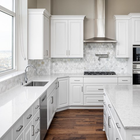 a white kitchen with marble counter tops and white cabinets at Expo, Minneapolis