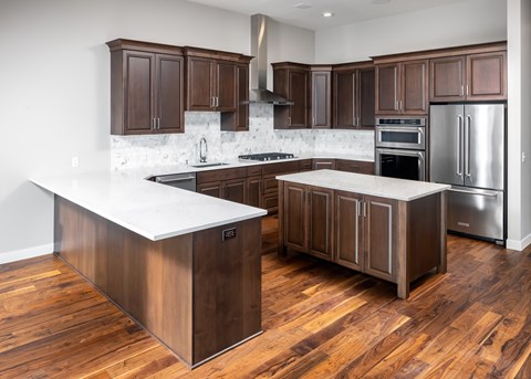 a kitchen with wooden cabinets and stainless steel appliances at Expo, Minneapolis, 55414