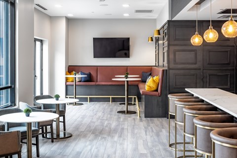 a lounge area with tables and chairs and a television at Expo, Minneapolis