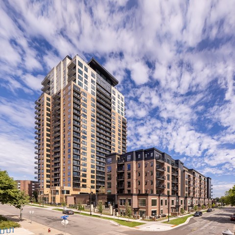 a tall apartment building on a city street under a cloudy sky at Expo, Minneapolis