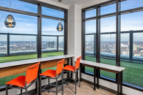 a dining room with a view of the city and a table with orange chairs at Expo, Minneapolis Minnesota