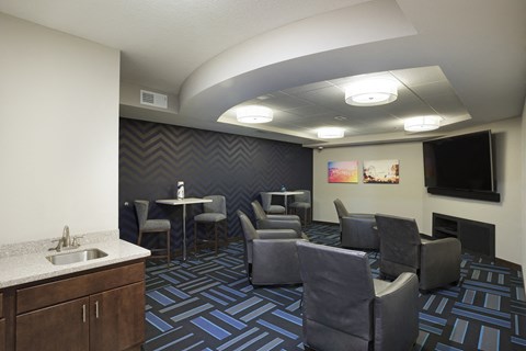 a living room with chairs and tables and a tv