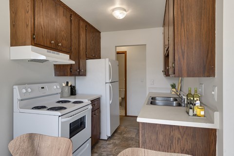 a kitchen with white appliances and wooden cabinets and a white refrigerator