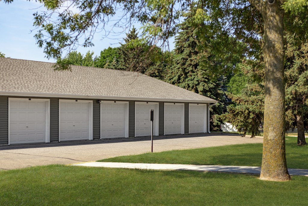 a large garage with white doors and a sidewalk