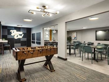 a foosball table in a game room with tables and chairs