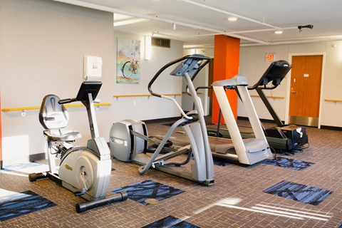 A gym with treadmills, elliptical machines, and stationary bikes.