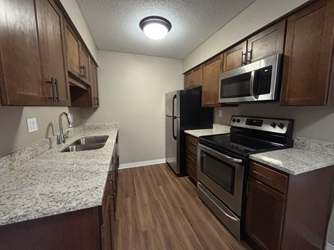 A kitchen with wooden cabinets and granite countertops.