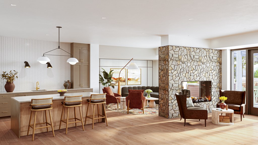 a living room with a stone fireplace and a kitchen with a bar and chairs at Lilia, Lilydale, Minnesota