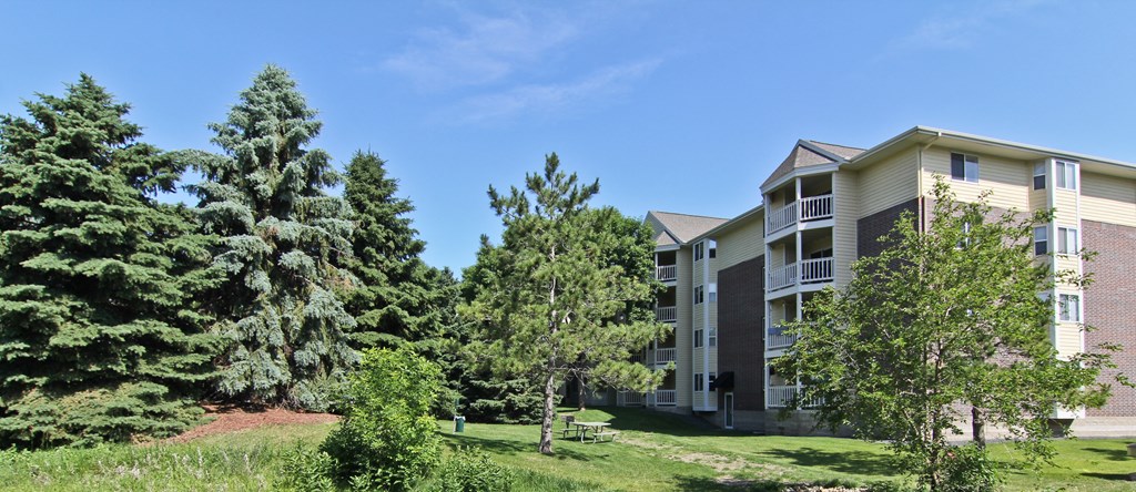 an apartment building on a hill with trees at Cityscape, St Louis Park, MN, 55416
