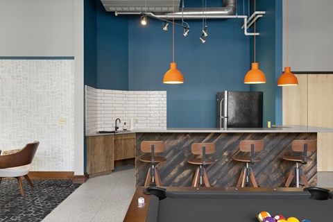 a recreation room with a pool table and a kitchen
