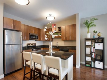 Kitchen Be @ Axon Green Apartment Kitchen with Wood Cabinets, Black Granite Island, and Stainless-Steel Appliances - Photo Gallery 2