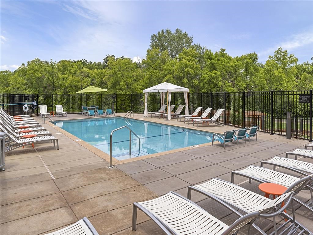 Be @ Axon Green Large blue pool with cabana and chairs around it