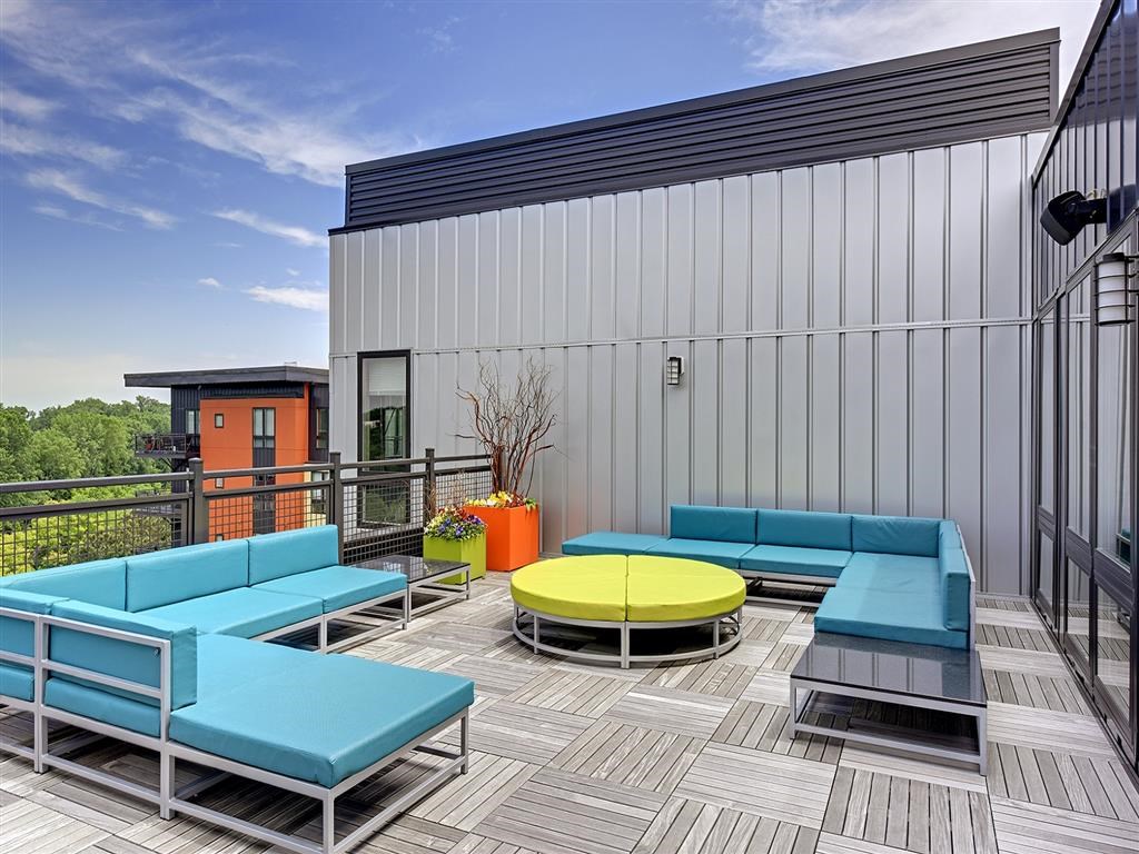 Be @ Axon Green Rooftop Patio lounge area with blue couches and green sofa table