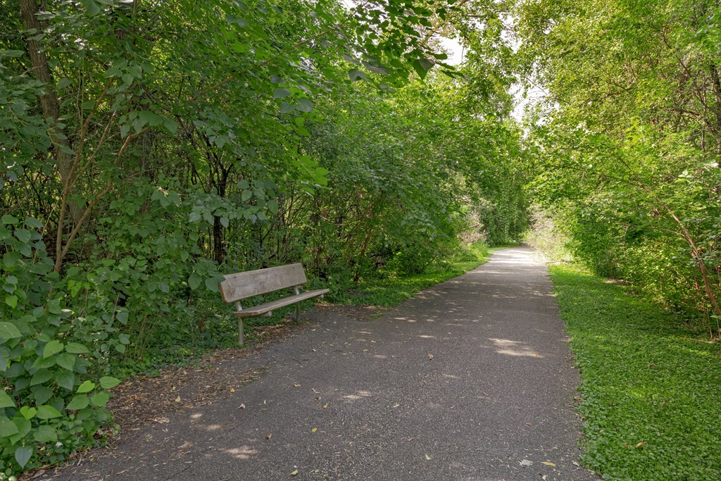 a park bench sitting on the side of a path