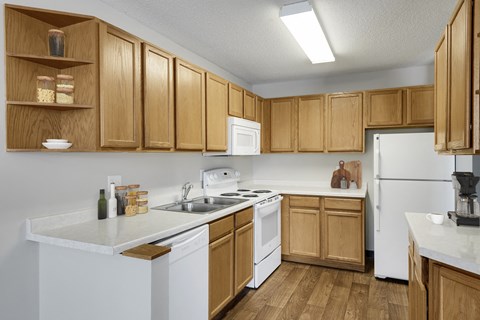 a kitchen with white appliances and wooden cabinets