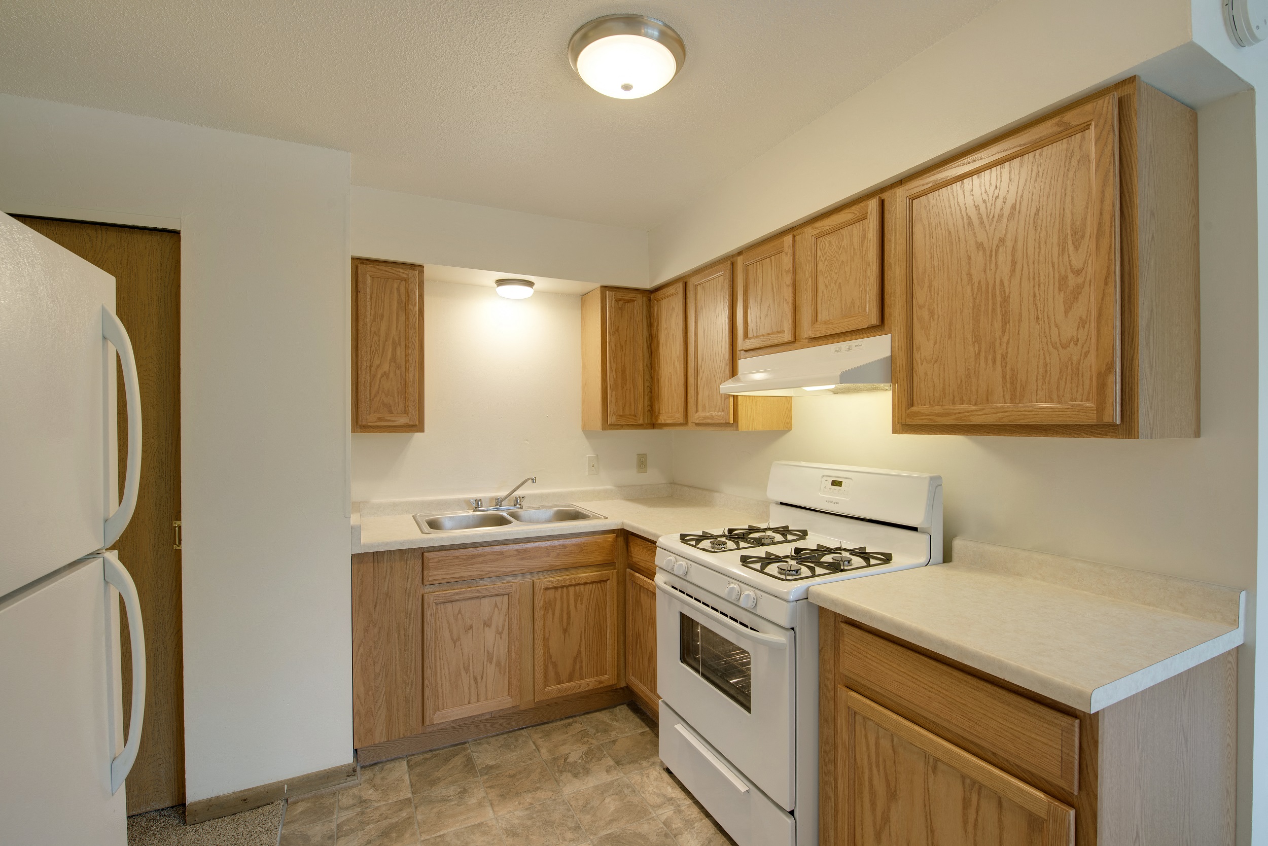 a kitchen with white appliances and wooden cabinets