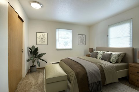 A bedroom with a bed, nightstand, and a plant.