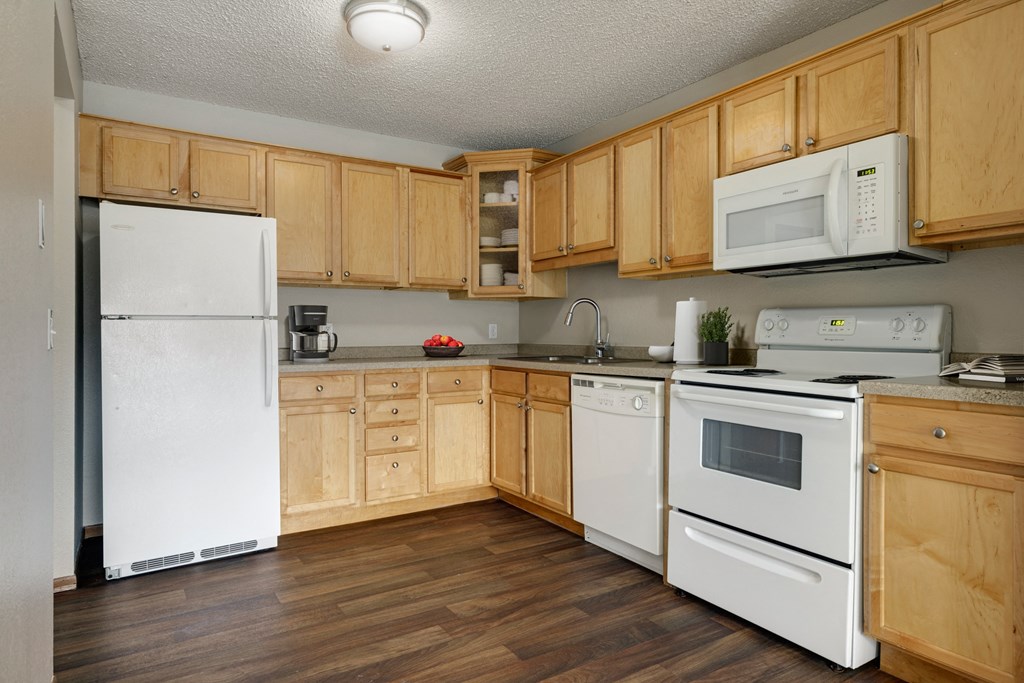 a kitchen with white appliances and wooden cabinets  at Park Pointe, Minnesota