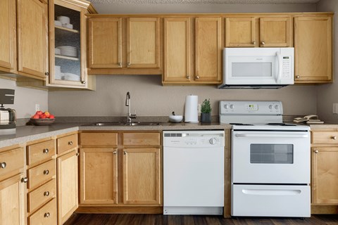 a kitchen with white appliances and wooden cabinets