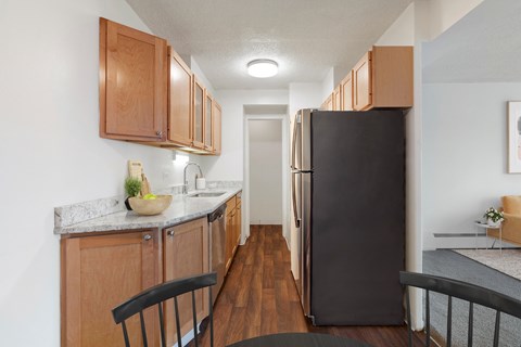 a kitchen with wooden cabinets and a black refrigerator