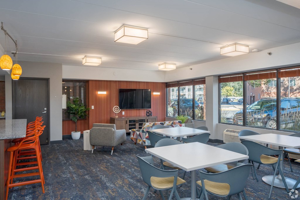 a lounge area with tables and chairs and a television at Park Pointe, St. Louis Park, Minnesota