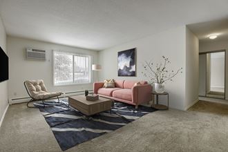 the living room of an apartment with a pink couch and a coffee table