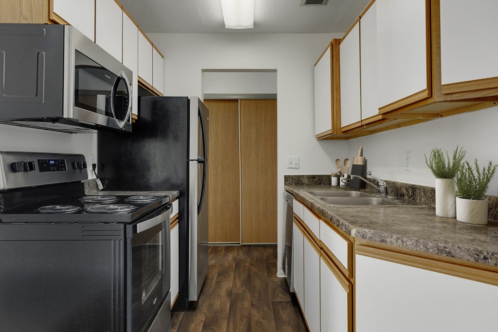 a kitchen with black appliances and granite counter tops and a black refrigerator